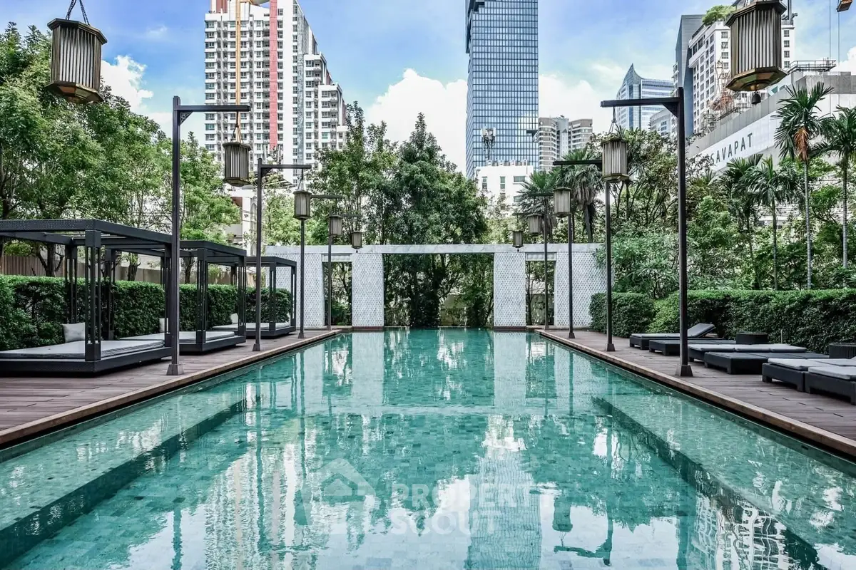 Luxurious urban pool area with city skyline views and lush greenery, perfect for relaxation and leisure.