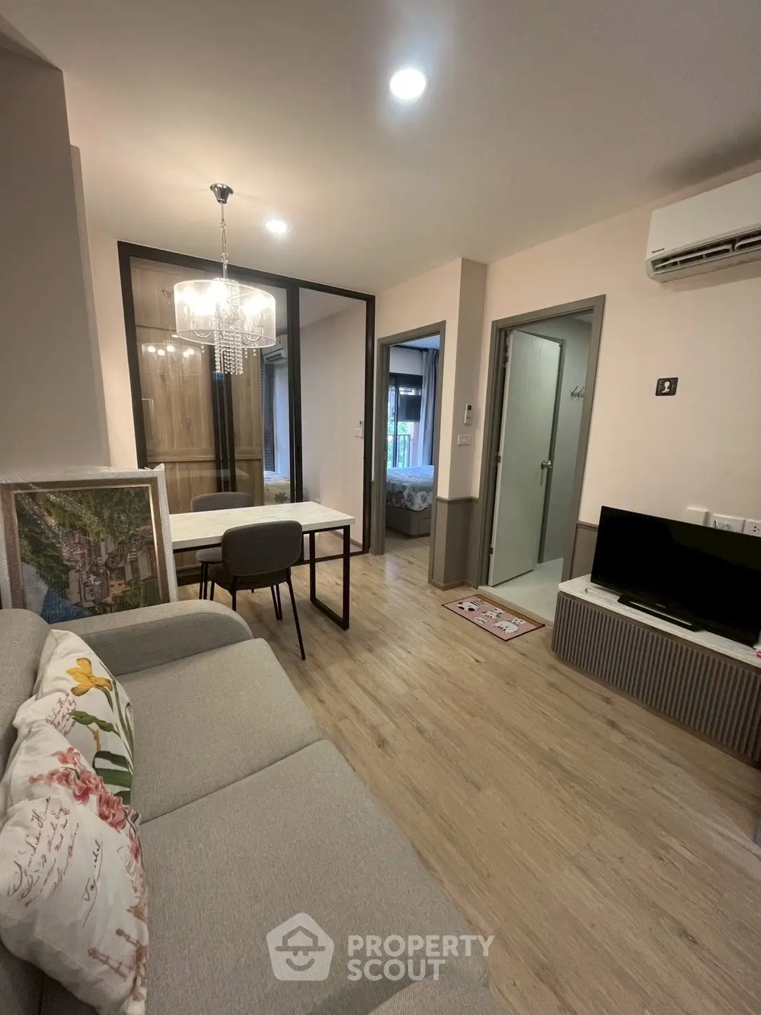 Modern living room with open layout, cozy sofa, and elegant lighting in a stylish apartment.