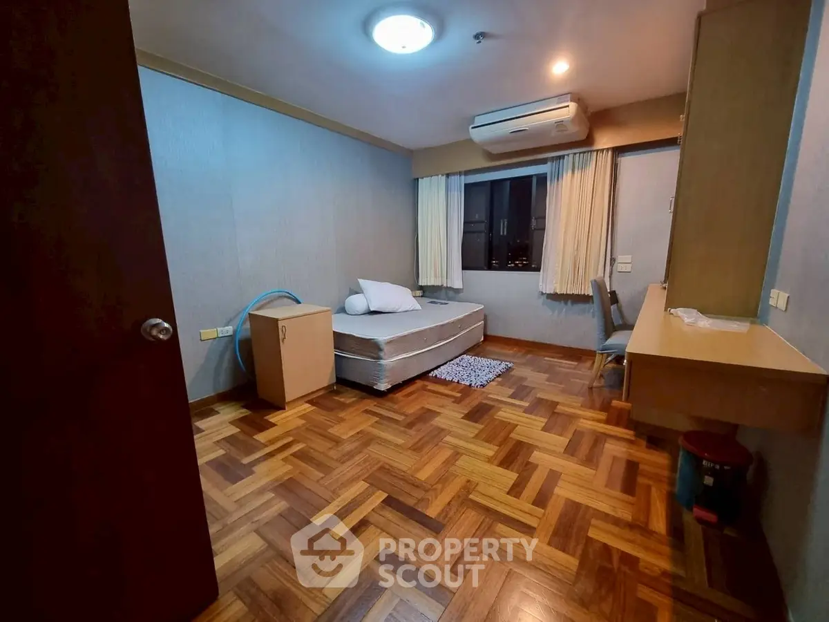 Cozy bedroom with parquet flooring and air conditioning in modern apartment