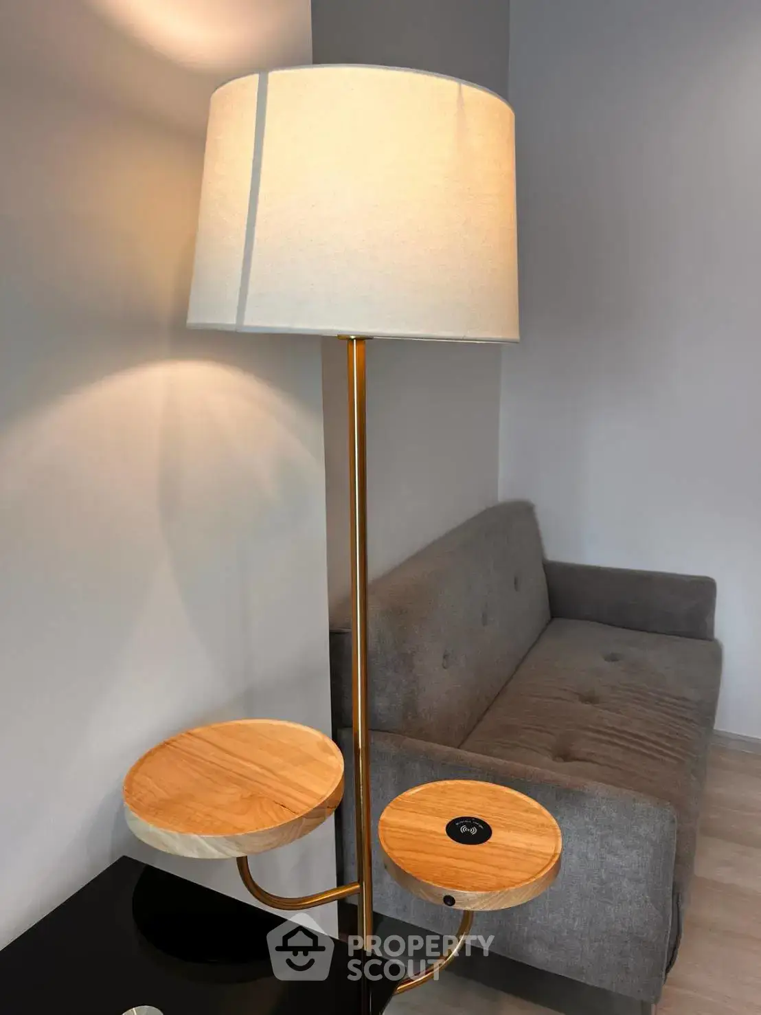 Modern living room with stylish floor lamp and cozy gray sofa, perfect for relaxation.