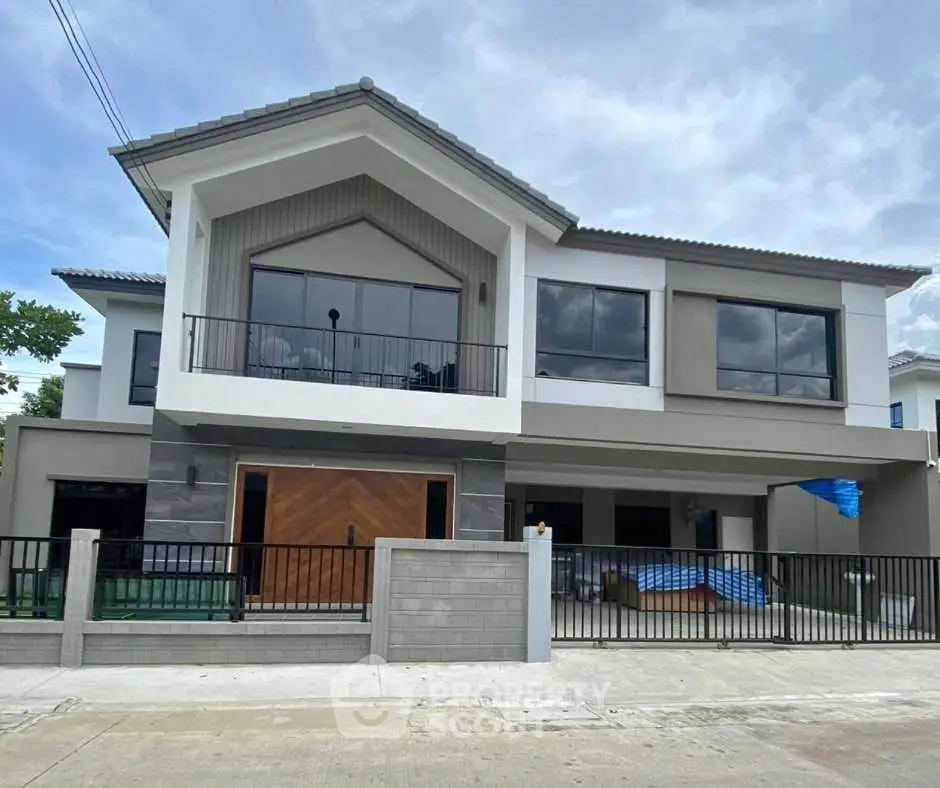 Modern two-story house with large windows and stylish facade in a suburban neighborhood.