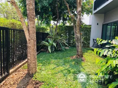 Charming garden area with lush greenery and trees, perfect for relaxation and outdoor activities.