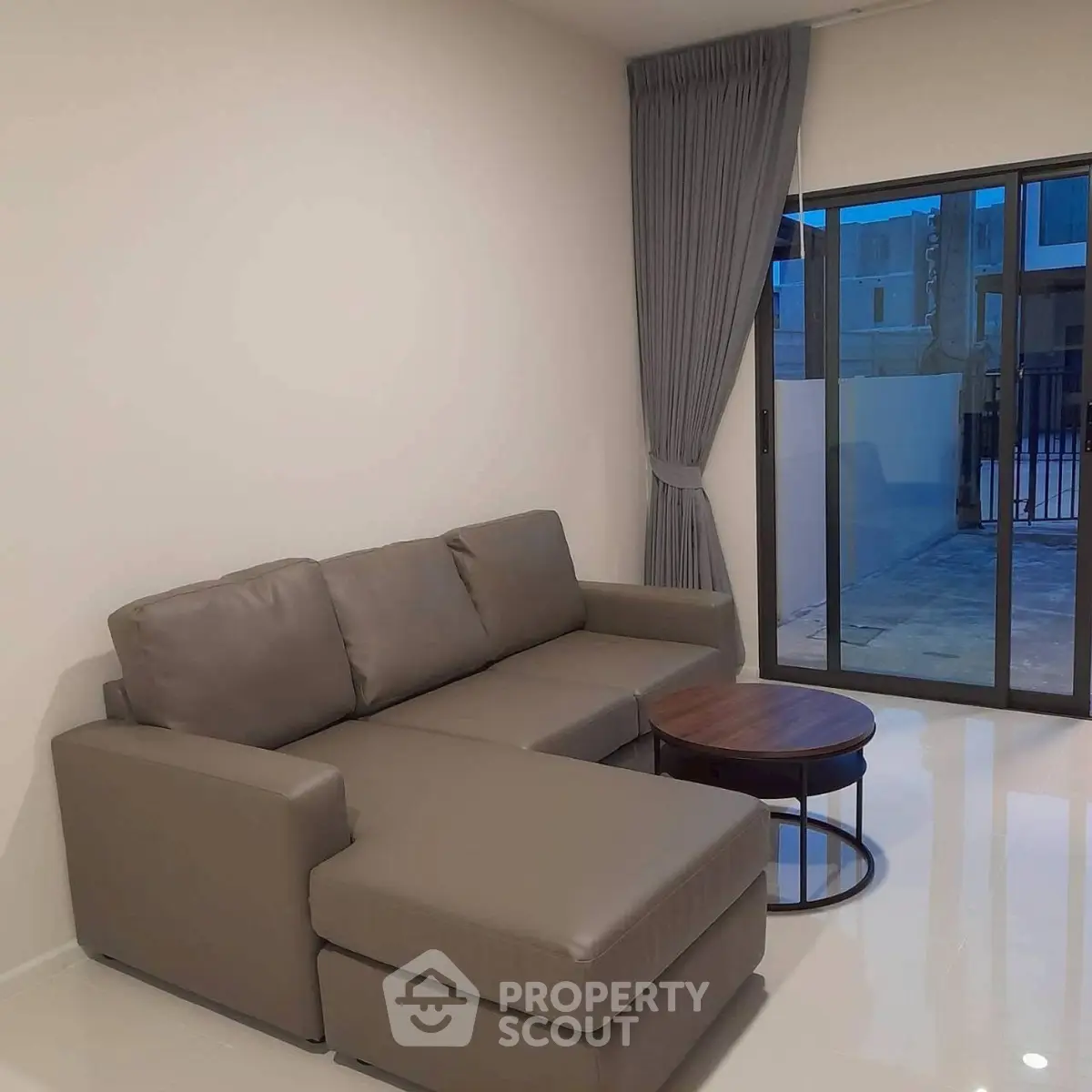 Modern living room with sleek gray sofa and glass sliding doors