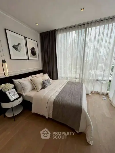 Luxurious bedroom with floor-to-ceiling windows and elegant decor in modern apartment.