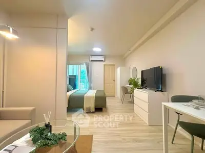 Modern studio apartment with open layout, featuring cozy living area and stylish bedroom.