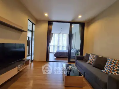 Modern living room with stylish decor and open view to bedroom, featuring cozy sofa and sleek TV unit.