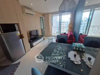 Modern living room with balcony view, sleek furniture, and stylish decor in a high-rise apartment.