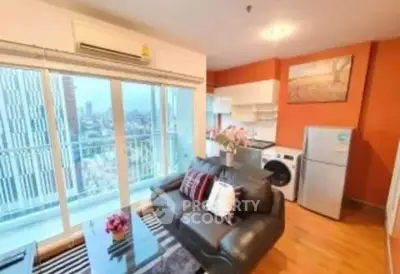 Modern living room with city view, stylish furniture, and open kitchen layout.