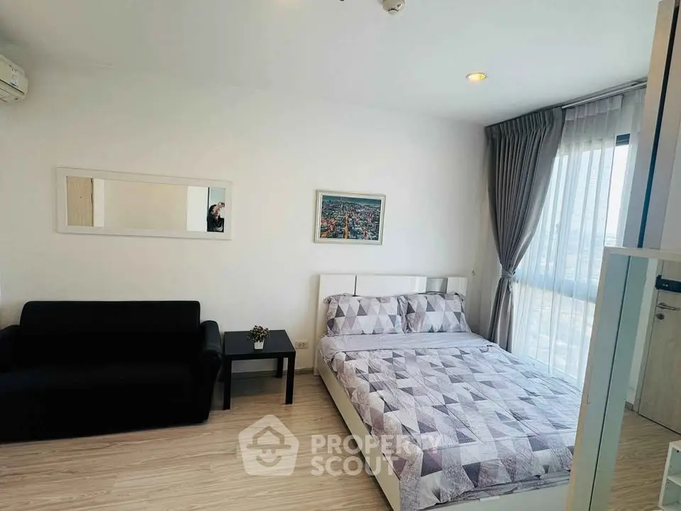 Modern bedroom with stylish decor and city view, featuring a cozy bed and elegant furnishings.
