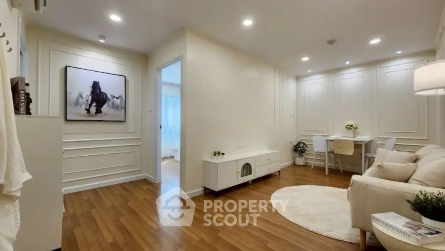 Elegant living room with wooden flooring, cozy seating, and stylish decor in a modern apartment.