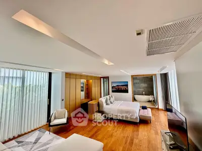 Luxurious bedroom with modern design, featuring a freestanding bathtub and elegant wooden flooring.