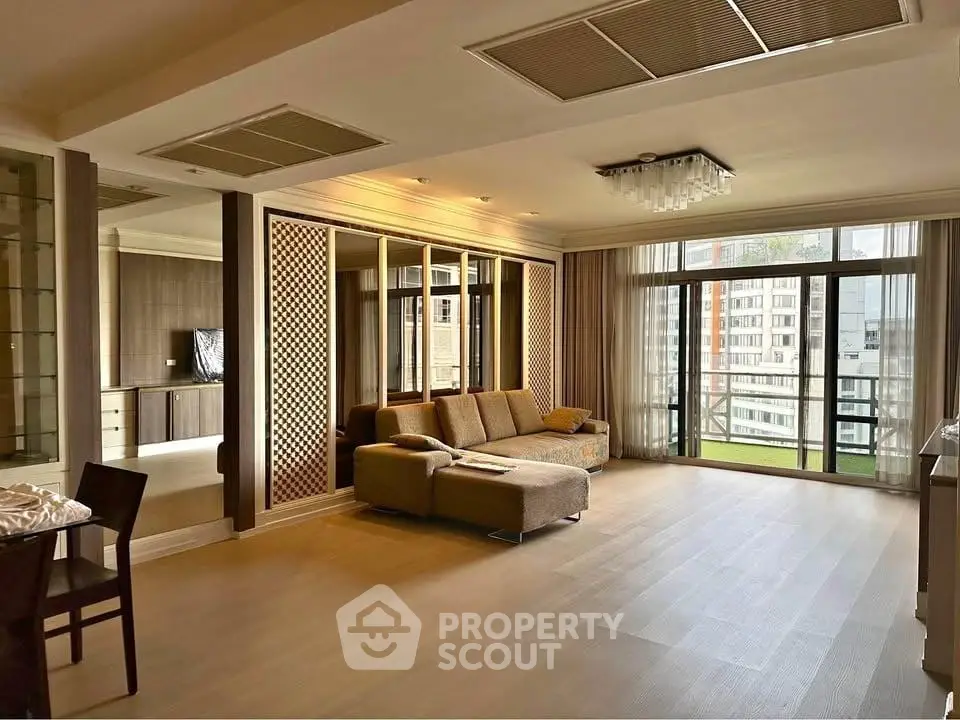 Spacious modern living room with large windows and elegant decor in a high-rise apartment.