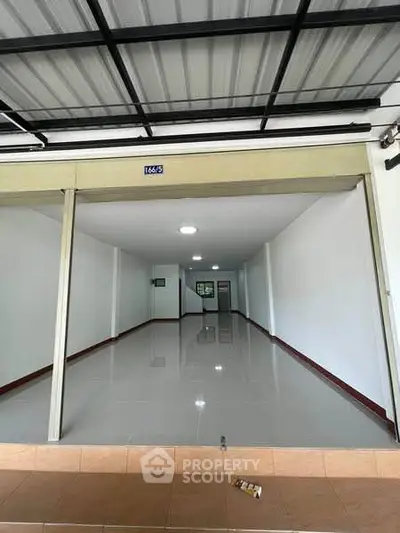 Spacious commercial unit with sleek tiled flooring and modern lighting, ideal for retail or office space.