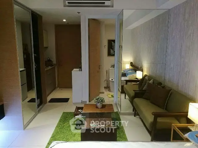 Stylish modern living room with cozy seating and green accents in a contemporary apartment.