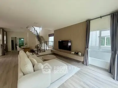 Spacious modern living room with elegant staircase and natural light
