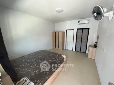 Spacious bedroom with modern furniture and air conditioning unit