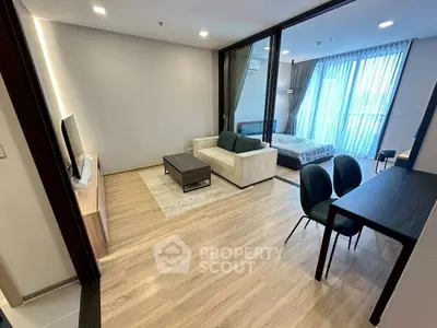 Modern open-plan living room and bedroom with stylish furniture and large windows.