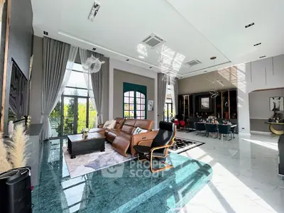 Luxurious living room with high ceilings, elegant decor, and abundant natural light.