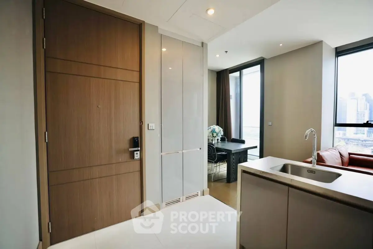 Modern apartment entrance with open kitchen and city view