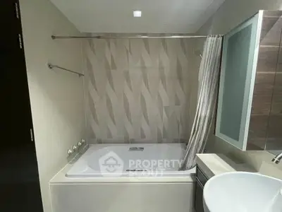 Modern bathroom with stylish bathtub and sleek fixtures in contemporary apartment.