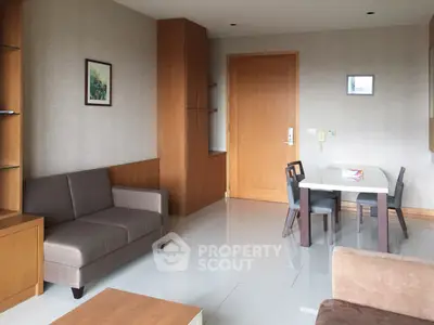 Modern living room with sleek furniture and dining area in a stylish apartment.