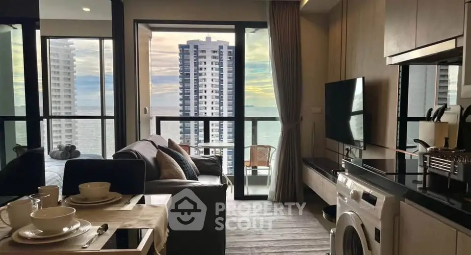Modern condo with ocean view, open living area, and balcony access, featuring stylish decor and natural light.