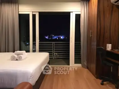 Modern bedroom with city view, featuring a cozy bed and stylish wooden decor.