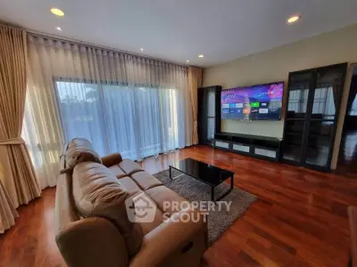 Spacious living room with modern decor and large windows offering natural light.