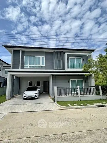 Modern two-story house with sleek design and carport in suburban neighborhood.