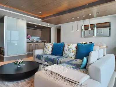 Luxurious living room with modern decor and open kitchen layout in upscale apartment.