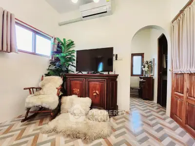 Charming living room with cozy decor and stylish flooring, featuring a TV and air conditioning.