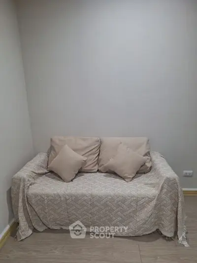 Cozy small living room with beige sofa and decorative pillows