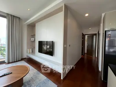 Modern living room with wall-mounted TV and wooden flooring in a stylish apartment.