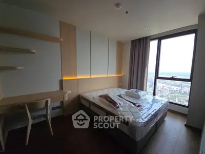 Modern bedroom with large window offering stunning city view, featuring a cozy bed and stylish wooden furniture.