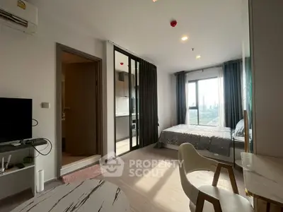 Modern studio apartment with open layout and city view, featuring stylish furniture and natural light.