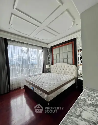 Luxurious bedroom with elegant decor and city view, featuring a plush bed and large window.