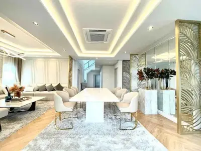 Luxurious open-plan living and dining area with elegant decor and modern lighting.