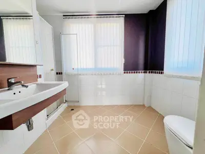 Spacious modern bathroom with large windows and sleek fixtures.