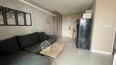 Modern living room with sleek black sofa and stylish decor in contemporary apartment.