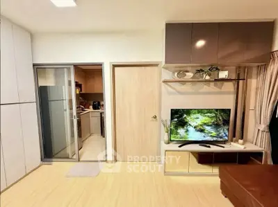Modern living room with sleek TV setup and sliding kitchen door