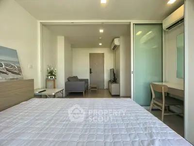 Modern bedroom with cozy seating area and study desk, perfect for urban living.
