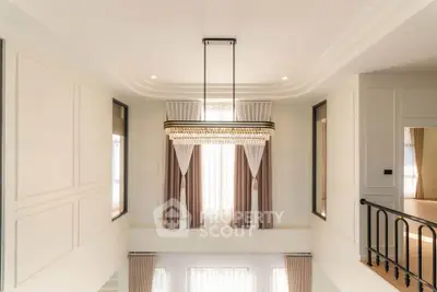 Elegant interior with high ceiling and modern chandelier in a luxurious home.