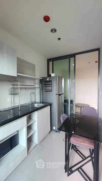 Modern kitchen with sleek appliances and dining area in a stylish apartment.