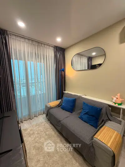 Cozy living room with stylish decor and large window offering natural light.