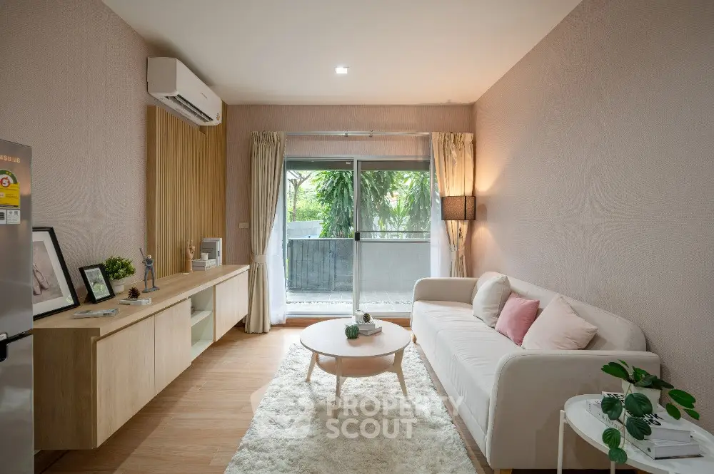 Modern living room with cozy sofa, stylish decor, and large window overlooking greenery.