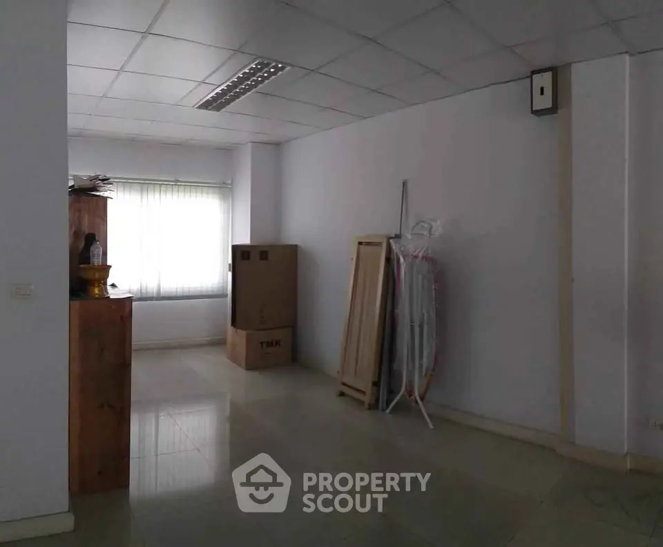 Spacious unfurnished room with large window and tiled floor, ideal for customization.