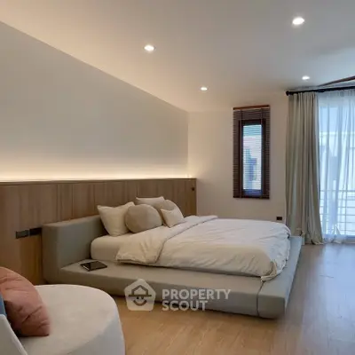Luxurious modern bedroom with elegant lighting and large windows for natural light.