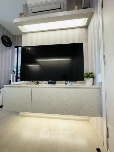 Modern living room with wall-mounted TV and sleek cabinetry