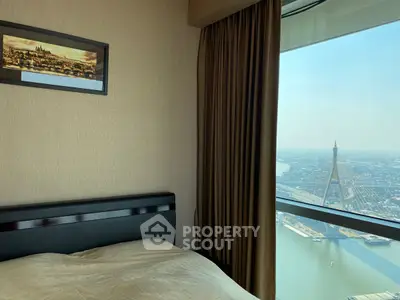Luxurious bedroom with stunning city and river view from high-rise window.