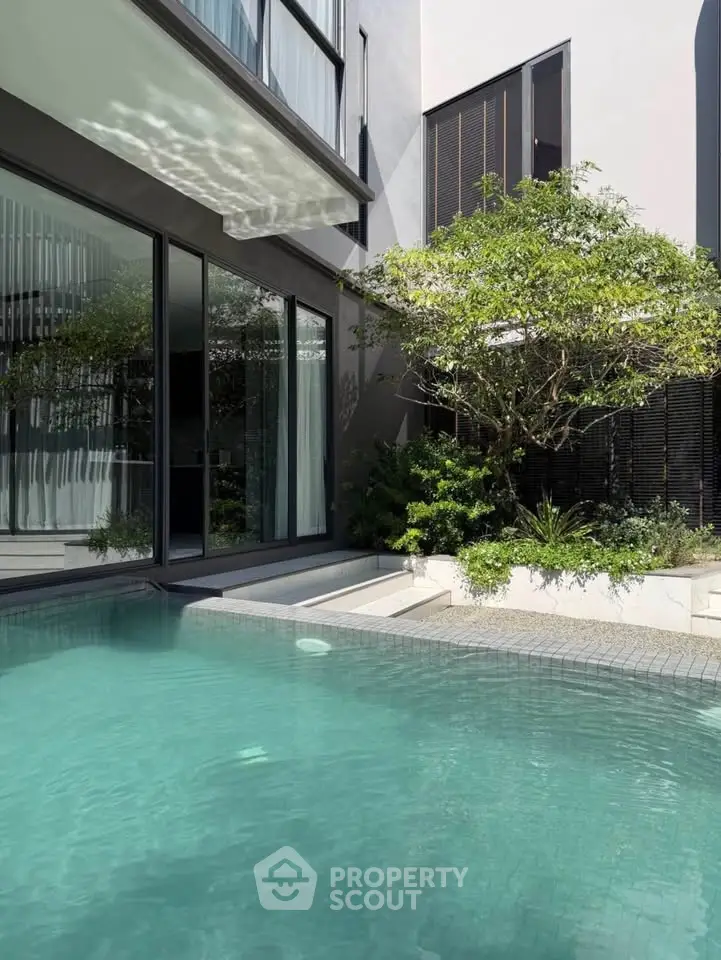 Luxurious modern home with private pool and lush greenery, perfect for relaxation and entertaining.